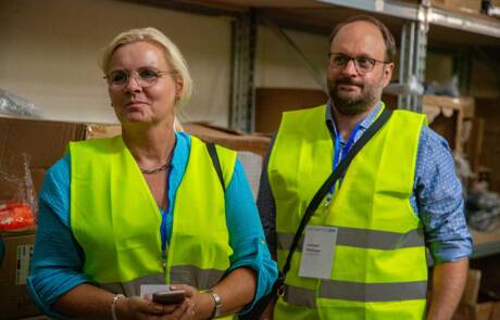Aufmerksames Zuhören der Teilnehmer während des Lagerrundgangs bei Sportspar.