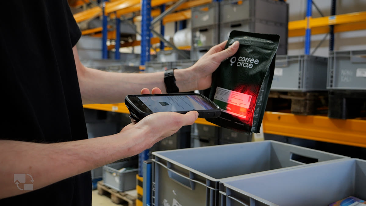 Hand mit mobilem Handscanner erfasst einen Artikel im E-Commerce-Lager Hand mit mobilem Handscanner erfasst einen Artikel im E-Commerce-Lager