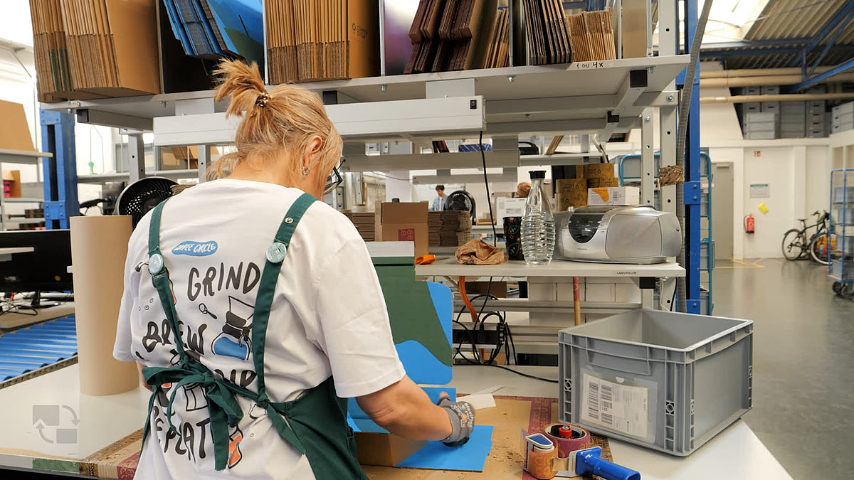 Mitarbeiterin packt Bestellungen am Packplatz während der saisonalen Hochphase Mitarbeiterin packt Bestellungen am Packplatz während der saisonalen Hochphase
